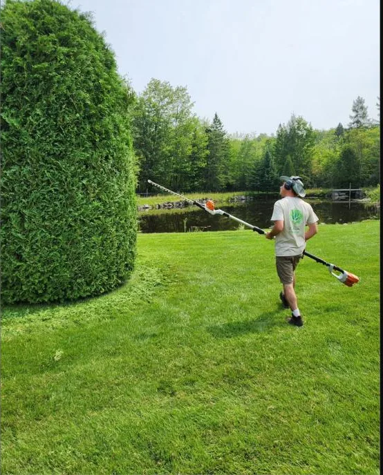 Paysagiste des Jardins Turgeon traversant un terrain entretenu